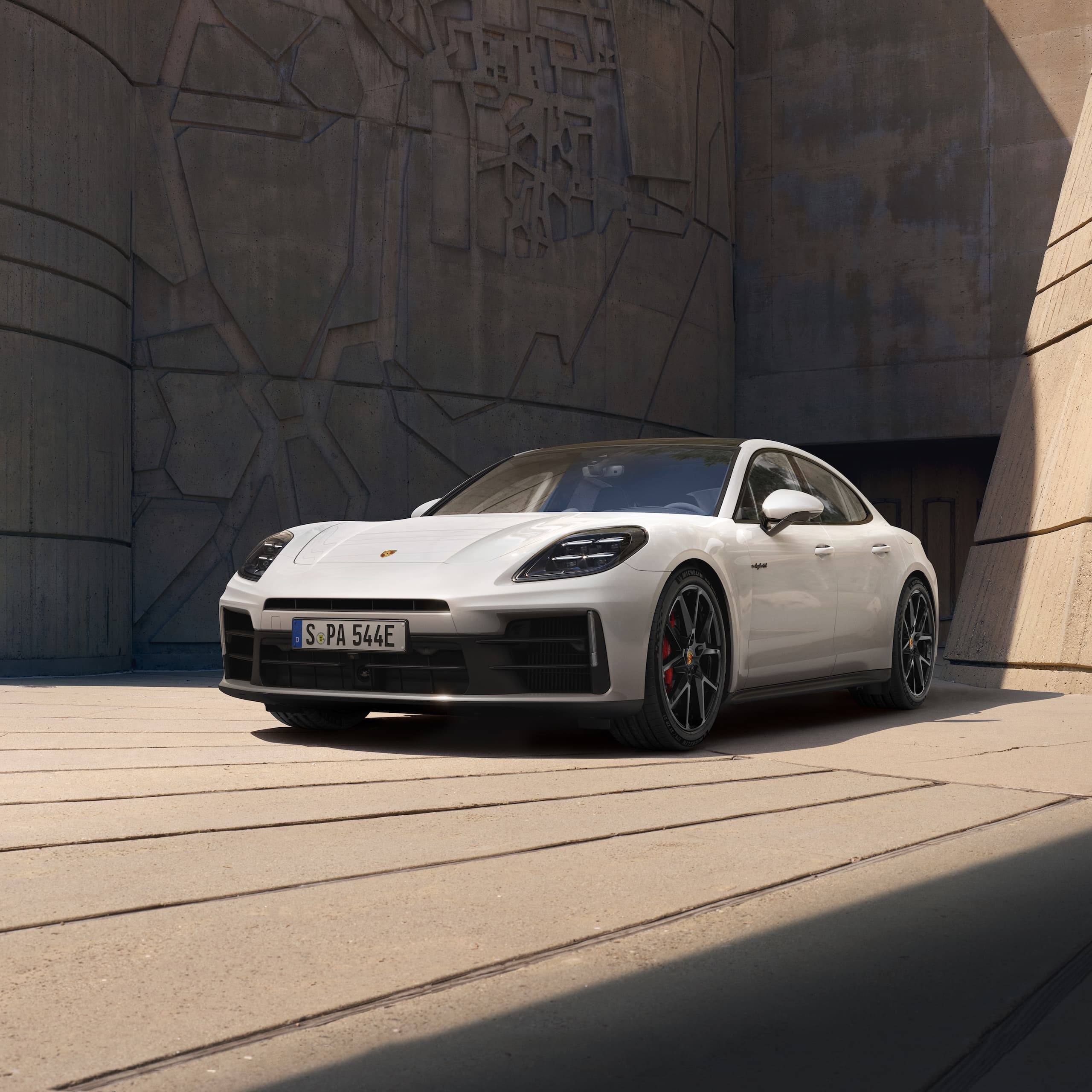 En Porsche Panamera parkerte foran en moderne bygning.